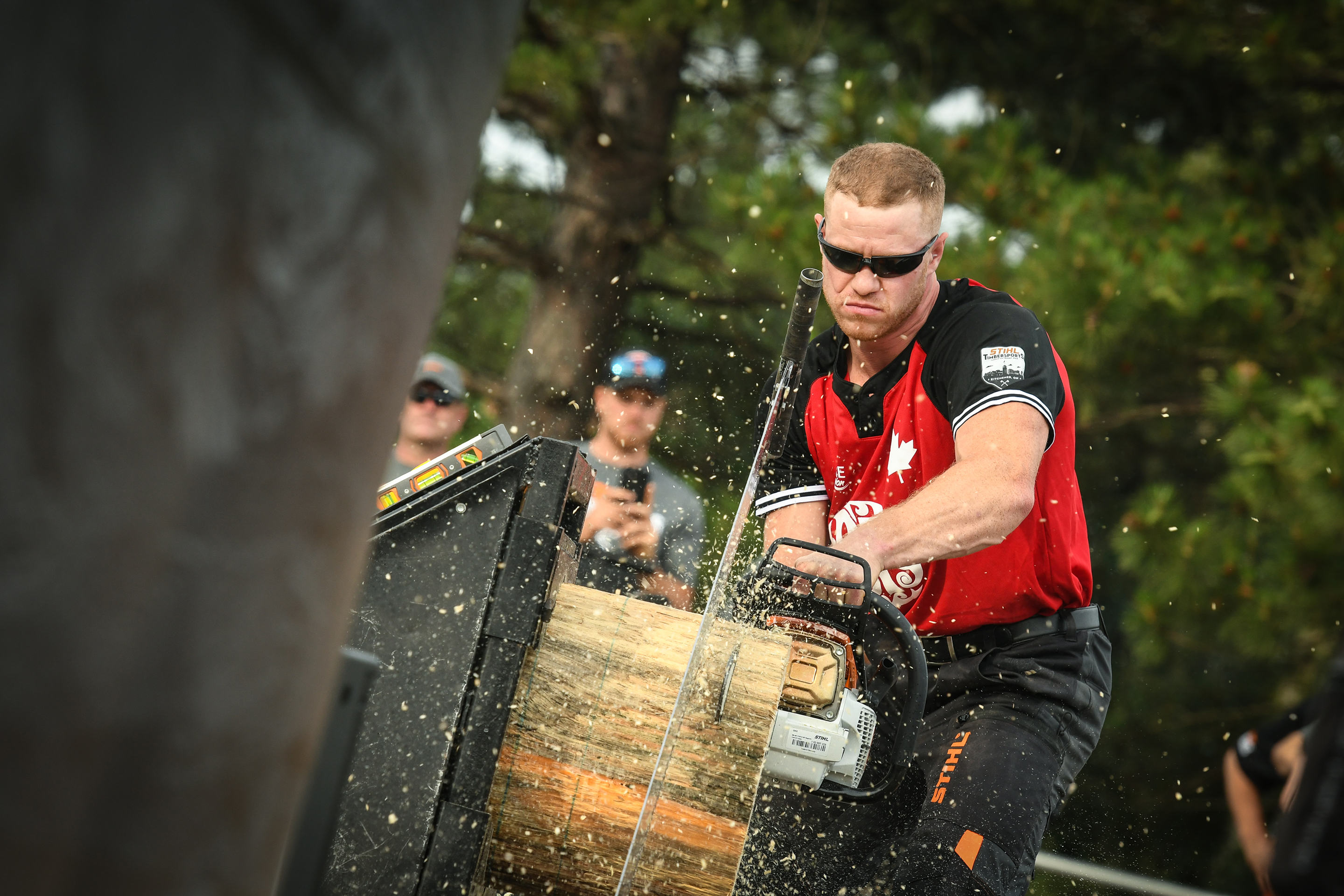 A STIHL TIMBERSPORTS® athlete sawing a tree trunk in a competition 